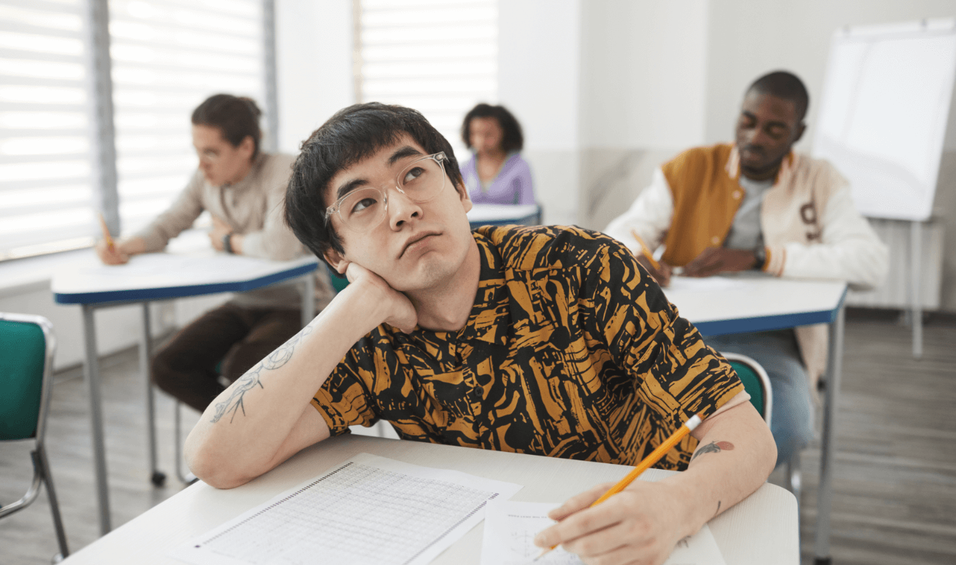 Student grübelt während des Einstufungstests Spanisch im Klassenzimmer über sein Sprachniveau nach.